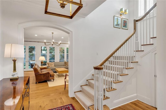 225 Ridgewood Dr, Metairie, LA 70005 - stairway featuring ornamental molding, a chandelier, wood finished floors, arched walkways, and recessed lighting