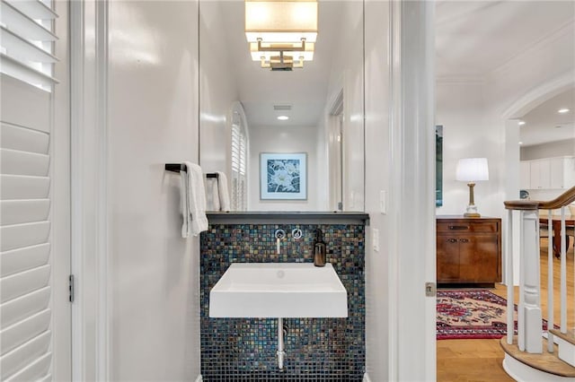 225 Ridgewood Dr, Metairie, LA 70005 - bathroom with visible vents, recessed lighting, wood finished floors, a sink, and backsplash