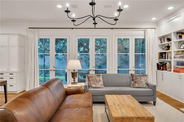 225 Ridgewood Dr, Metairie, LA 70005 - living area featuring a notable chandelier, french doors, light wood-type flooring, and ornamental molding