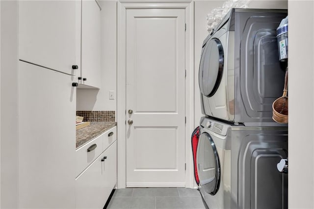225 Ridgewood Dr, Metairie, LA 70005 - laundry area featuring tile patterned flooring, stacked washer / drying machine, and cabinet space