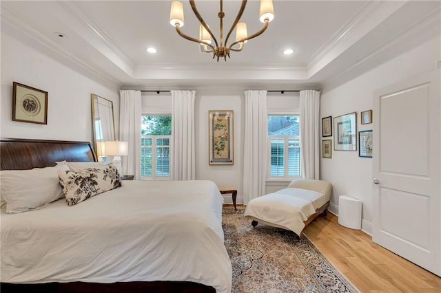 225 Ridgewood Dr, Metairie, LA 70005 - bedroom with a tray ceiling, ornamental molding, multiple windows, a chandelier, and light wood-type flooring