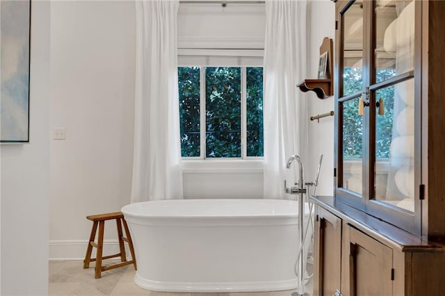 225 Ridgewood Dr, Metairie, LA 70005 - full bath featuring a freestanding bath, baseboards, and a wealth of natural light