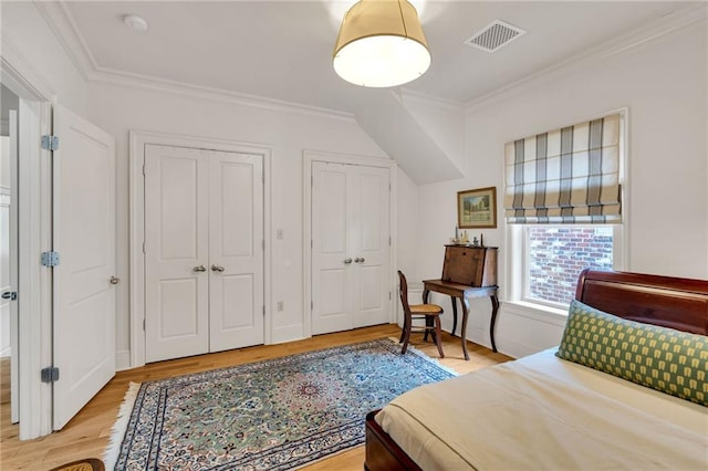 225 Ridgewood Dr, Metairie, LA 70005 - bedroom featuring multiple closets, light wood-style floors, and ornamental molding
