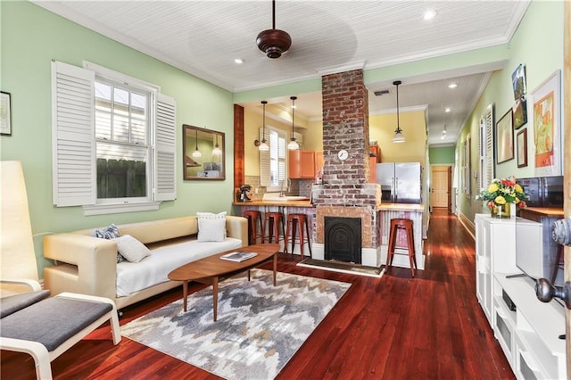 living room with dark wood-style floors, a healthy amount of sunlight, ornamental molding, and visible vents