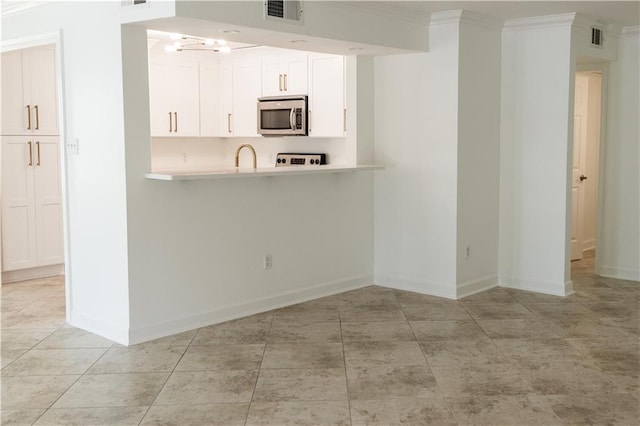 272 Marina Dr, Slidell, LA 70458 - kitchen featuring light countertops, baseboards, stainless steel microwave, and visible vents