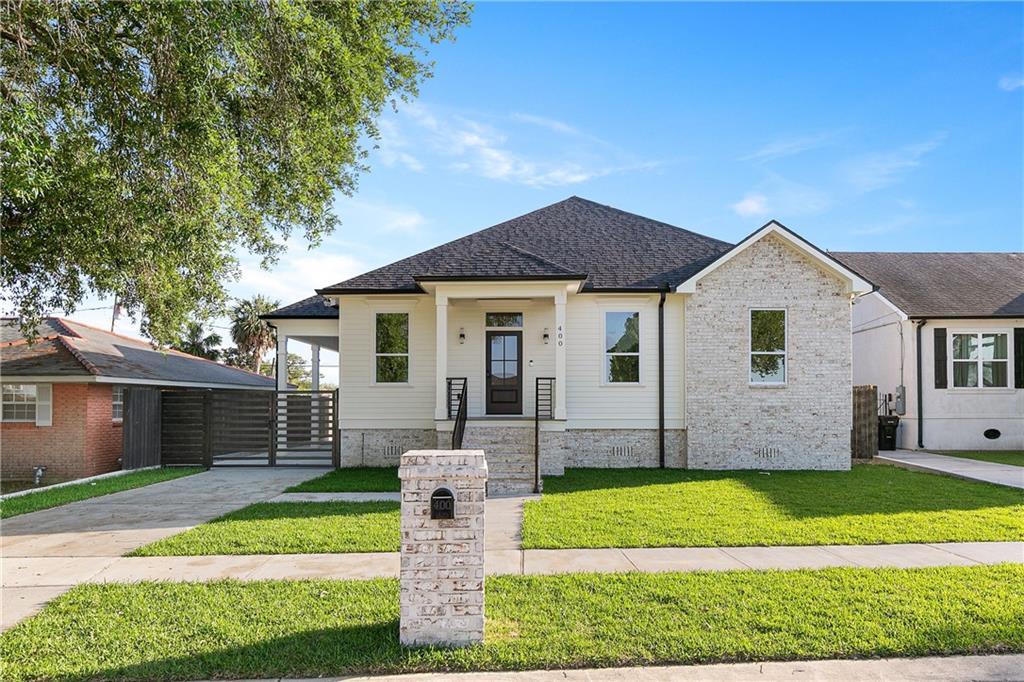 400 Mink Dr, Arabi, LA 70032 - view of front of property featuring a front yard and a shingled roof