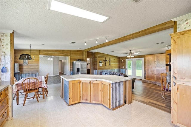1510 Pumping Station Rd, Greensburg, LA 70441 - kitchen with stainless steel fridge with ice dispenser, ceiling fan, a textured ceiling, and wooden walls