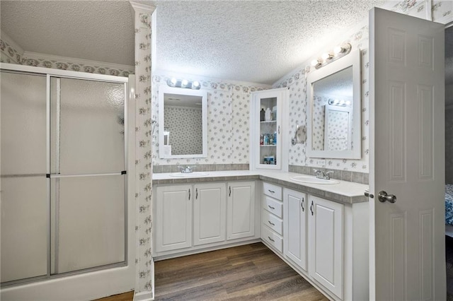 1510 Pumping Station Rd, Greensburg, LA 70441 - bathroom with wallpapered walls, a textured ceiling, a sink, and a stall shower