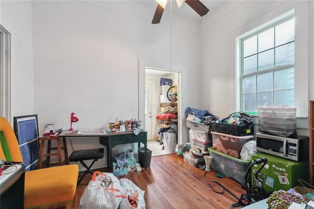 misc room with wood finished floors and a ceiling fan