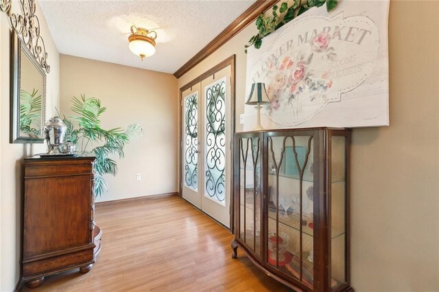 313 Sarah Victoria Dr, Belle Chasse, LA 70037 - foyer featuring a textured ceiling, light wood finished floors, baseboards, and ornamental molding