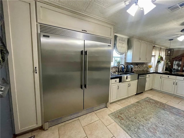313 Sarah Victoria Dr, Belle Chasse, LA 70037 - kitchen with a ceiling fan, backsplash, dark countertops, appliances with stainless steel finishes, and a sink