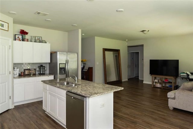 kitchen featuring a sink, open floor plan, a center island with sink, dark wood-type flooring, and stainless steel appliances