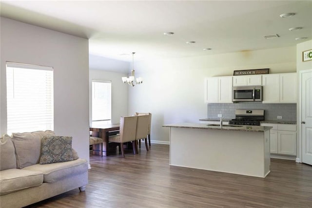 kitchen featuring tasteful backsplash, a chandelier, white cabinetry, appliances with stainless steel finishes, and a sink