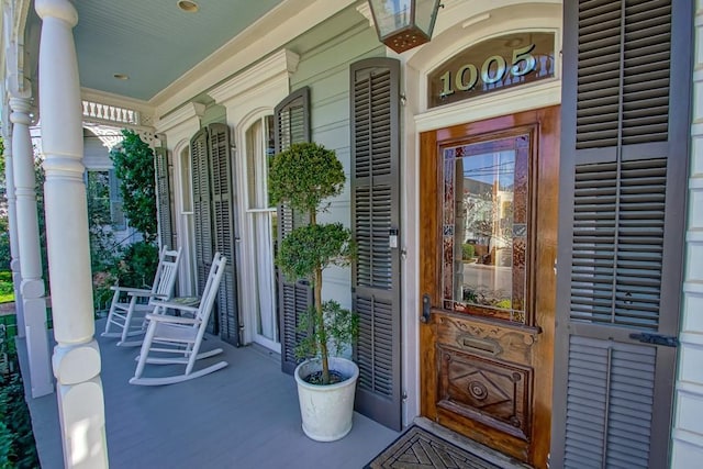 view of exterior entry featuring covered porch