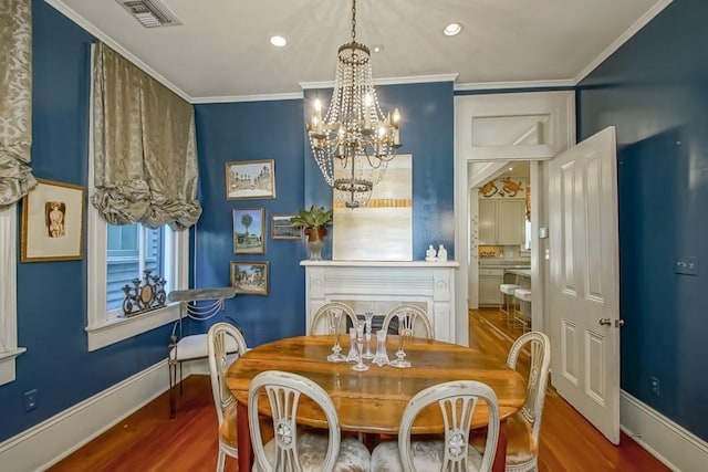 dining space with a chandelier, wood finished floors, recessed lighting, crown molding, and baseboards