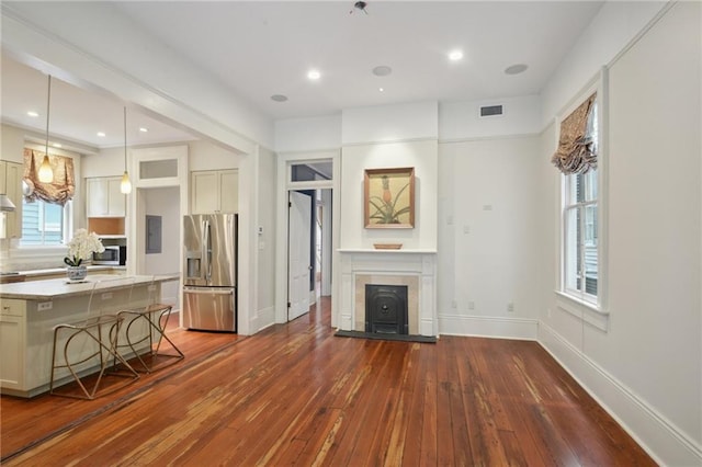 living room featuring dark wood-style flooring, baseboards, a tiled fireplace, and recessed lighting