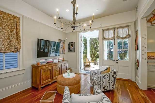 dining space featuring dark wood-type flooring, a chandelier, and baseboards