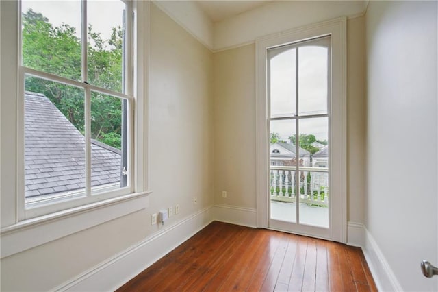 doorway featuring dark wood-style floors and baseboards