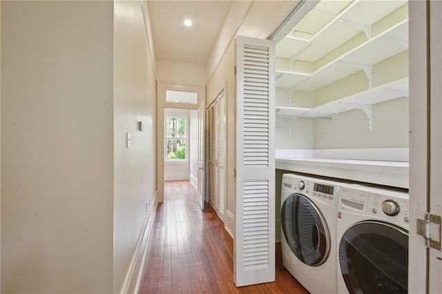 washroom featuring washing machine and clothes dryer, hardwood / wood-style flooring, and baseboards