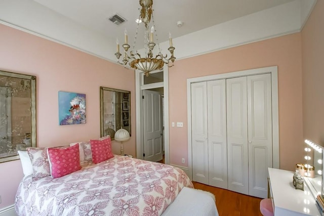 bedroom featuring a chandelier, a closet, and wood finished floors