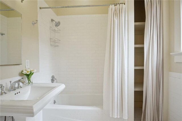 bathroom with shower / tub combo and a sink