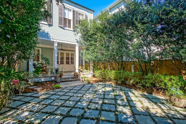 rear view of property with ceiling fan and a patio