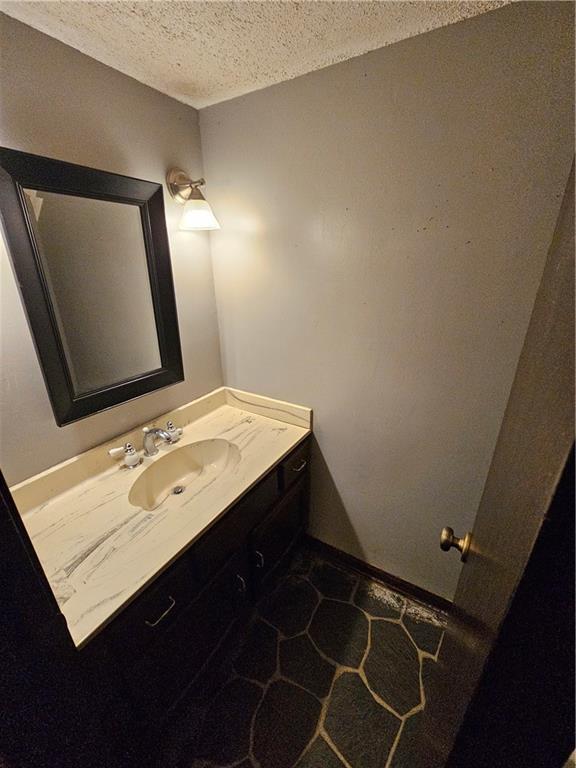 bathroom featuring a textured ceiling and vanity