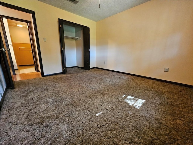unfurnished bedroom with baseboards, carpet flooring, and a textured ceiling