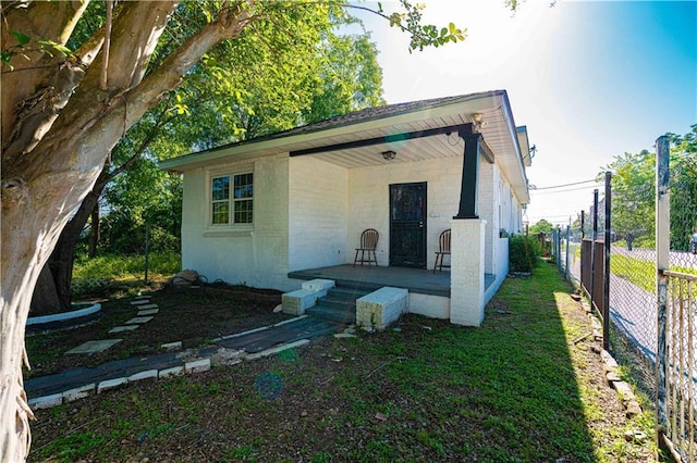 view of outdoor structure with a porch and fence