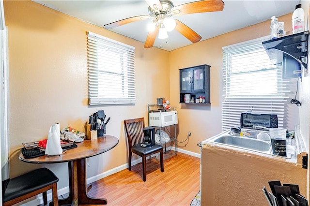 home office with light wood-style floors, baseboards, ceiling fan, and a toaster