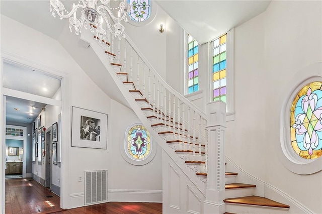 3418 Coliseum St, New Orleans, LA 70115 - staircase with baseboards, wood finished floors, visible vents, and a towering ceiling