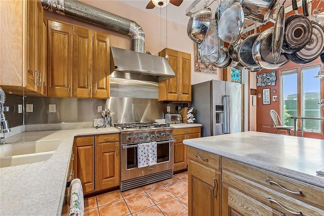 3418 Coliseum St, New Orleans, LA 70115 - kitchen featuring brown cabinets, high quality appliances, ceiling fan, and a sink