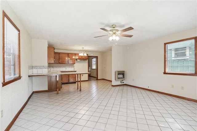 2617 Danneel St, New Orleans, LA 70113 - living area featuring ceiling fan with notable chandelier, light tile patterned floors, baseboards, and heating unit