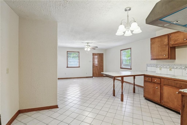 2617 Danneel St, New Orleans, LA 70113 - kitchen featuring tile countertops, extractor fan, baseboards, and a healthy amount of sunlight