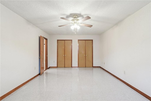 2617 Danneel St, New Orleans, LA 70113 - unfurnished bedroom with baseboards, a ceiling fan, two closets, and light floors