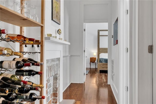 corridor featuring dark wood-type flooring and wainscoting
