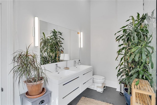 bathroom featuring a sink, tile patterned floors, toilet, and double vanity
