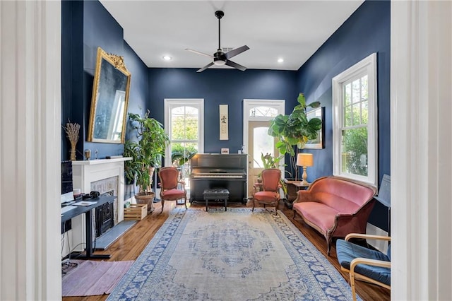 sitting room featuring ceiling fan, wood finished floors, and a fireplace