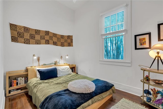 bedroom with baseboards and wood finished floors