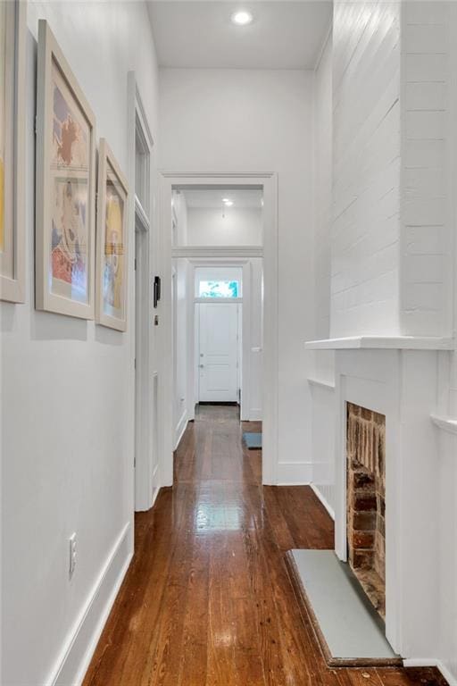 hallway featuring baseboards, recessed lighting, and wood finished floors