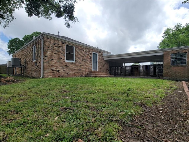 2202 Fazzio Rd, Chalmette, LA 70043 - back of house with brick siding, a yard, central AC unit, and fence