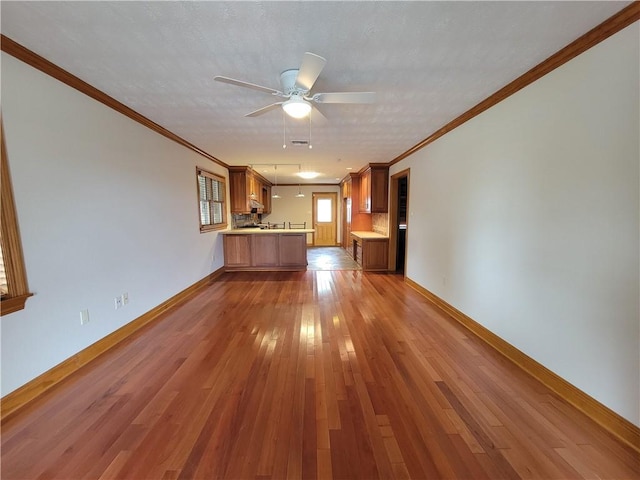 2202 Fazzio Rd, Chalmette, LA 70043 - unfurnished living room with crown molding, baseboards, light wood finished floors, and ceiling fan