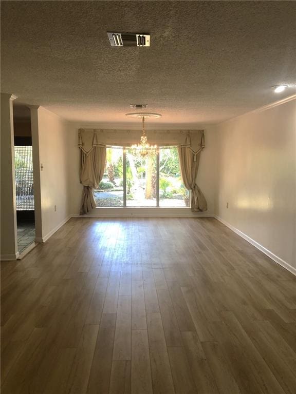 711 Roseland Pkwy, Harahan, LA 70123 - empty room featuring a chandelier, a textured ceiling, baseboards, and wood finished floors