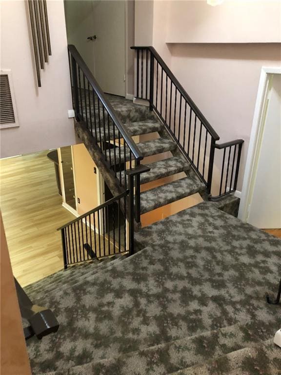 stairs featuring visible vents and wood finished floors