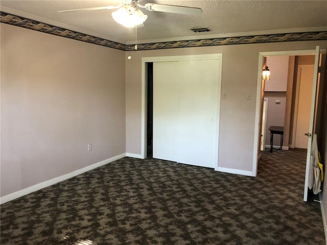 unfurnished bedroom featuring baseboards, dark colored carpet, visible vents, and a closet
