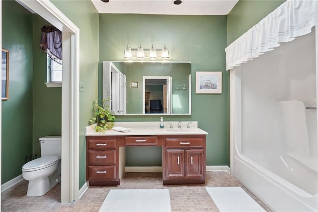 bathroom with vanity, baseboards, and toilet