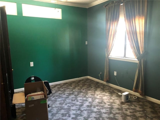 unfurnished office featuring baseboards, carpet floors, and crown molding
