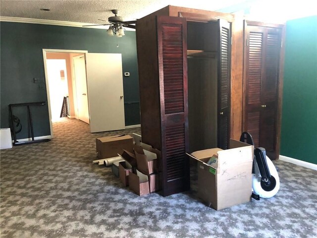 interior space featuring carpet, baseboards, ornamental molding, and ceiling fan