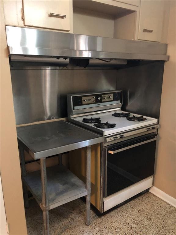 711 Roseland Pkwy, Harahan, LA 70123 - kitchen with white gas stove, white cabinetry, baseboards, and dark speckled floor
