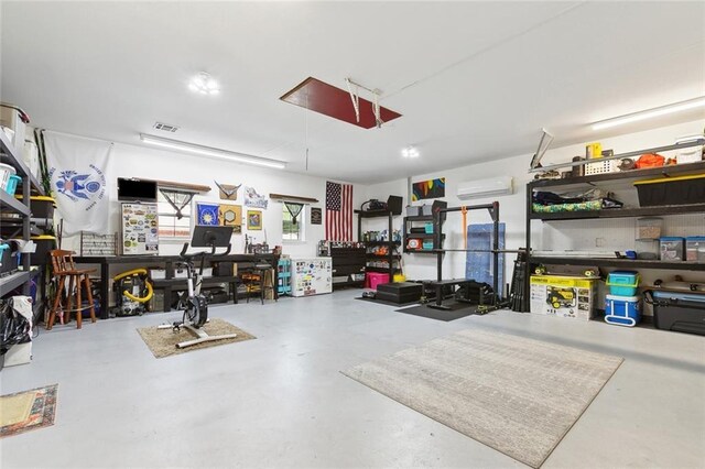 155 Maud Olive Dr, Belle Chasse, LA 70037 - garage featuring an AC wall unit, visible vents, and a workshop area